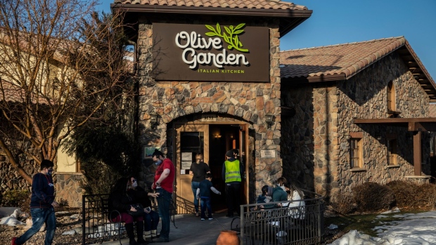 Diners wearing protective masks wait outside an Olive Garden restaurant in Thornton, Colorado, U.S., on Friday, March 19, 2021. Darden Restaurants Inc. is scheduled to release earnings figures on March 25.