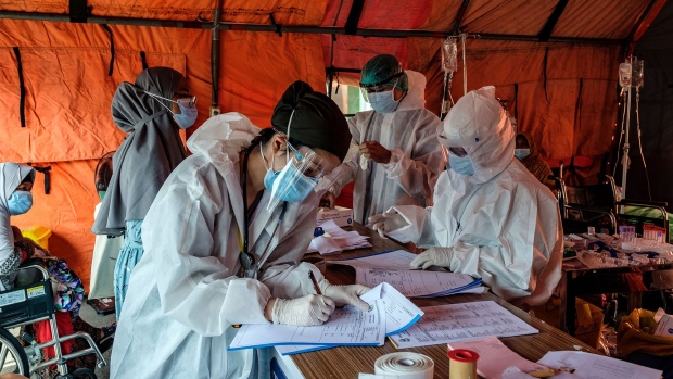 BEKASI, INDONESIA - JUNE 24: Busy nurses handle the paperwork for incoming patients in a tent set up to handle an overflow of Covid-19 patients at a hospital in a town bordering Jakarta on June 24, 2021 in Bekasi, Indonesia. Indonesia has been facing a rapid rise in Covid-19 cases over the past several weeks from roughly 6,000 new cases per day a month ago to the current level of over 15,000 new cases per day. The Jakarta government, which has seen its quarantine facilities nearly at capacity and several hospitals facing a shortage of beds to treat patients has put curfews and other social restrictions in place to try to reduce the spread of the disease but has so far stopped short of full lockdown. (Photo by Ed Wray/Getty Images)