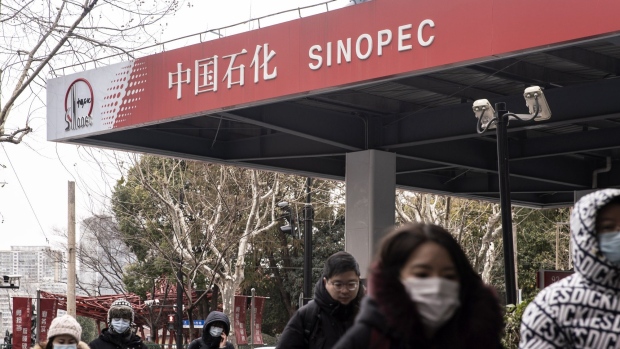 Pedestrians walk past a China Petroleum & Chemical Corp. (Sinopec) gas station in Shanghai, China, on Thursday, Jan. 7, 2021. China's energy markets are tightening as the economy rebounds and freezing weather grips much of the northern hemisphere, a dynamic that’s likely to be exacerbated by reduced Saudi oil output. Photographer: Qilai Shen/Bloomberg