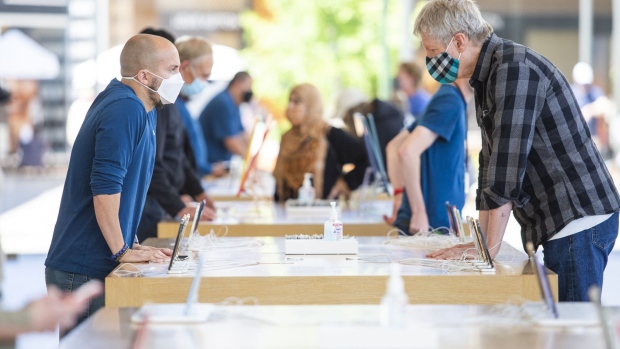 An employee helps a customer at an Apple store in Palo Alto, California.