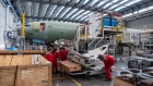 Employees maneuver fuselage panels as an Airbus A330neo passenger aircraft stands on the final assembly line at the Airbus SE factory in Toulouse, France, on Monday, Nov. 26, 2018. Known as the A330neo for New Engine Option, the model was originally scheduled to join the TAP Air Portugal fleet from the end of 2017. Photographer: Balint Porneczi/Bloomberg