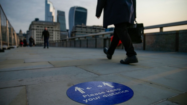 Commuters pass a social distancing marker on London Bridge. Photographer: Hollie Adams/Bloomberg