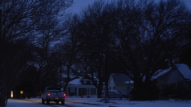 A truck drives down the street during a power outage in McKinney, Texas, U.S., on Tuesday, Feb. 16, 2021. The energy crisis crippling the U.S. showed few signs of abating Tuesday as blackouts left almost 5 million customers without electricity, while refineries and oil wells were shut during unprecedented freezing weather.