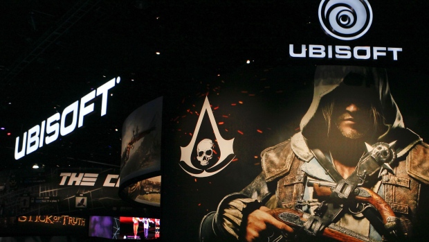Attendees walk past signage for UbiSoft Entertainment SA's Assassin's Creed IV: Black Flag video game during the E3 Electronic Entertainment Expo in Los Angeles, California, U.S., on Wednesday, June 12, 2013. E3, a trade show for computer and video games, draws professionals to experience the future of interactive entertainment as well as to see new technologies and never-before-seen products. Photographer: Bloomberg/Bloomberg