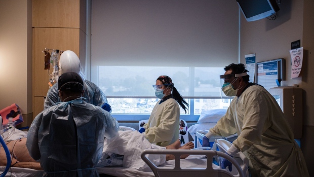 Healthcare workers tend to a patient in the Covid-19 Intensive Care Unit (ICU) overflow area at Providence Holy Cross Medical Center in Mission Hills, California, U.S., on Friday, Feb. 5, 2021. California’s 14-day positive test rate dropped to 6.6%, down from 12.7% a month ago and the lowest since Nov. 30. Photographer: Ariana Drehsler/Bloomberg