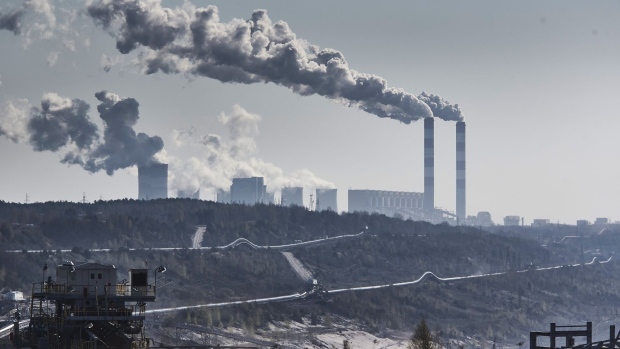 Vapor rises from chimneys and cooling towers at the Belchatow coal powered power plant beyond an open cast lignite mine, operated by PGE SA, in Belchatow, Poland, on April 28, 2021. 