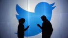 People are seen as silhouettes as they check mobile devices whilst standing against an illuminated wall bearing Twitter Inc.'s logo in this arranged photograph in London, U.K., on Tuesday, Jan. 5, 2016. Twitter Inc. may be preparing to raise its character limit for tweets to the thousands from the current 140, a person with knowledge of the matter said. Photographer: Bloomberg/Bloomberg