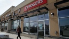 A pedestrian walks past a Rogers store in Winnipeg, Manitoba, Canada, on Monday, March 15, 2021. Rogers Communications Inc. agreed to buy rival Shaw Communications Inc. in a C$20 billion ($16 billion) deal that would unite Canada's two largest cable providers and shake up its wireless industry.