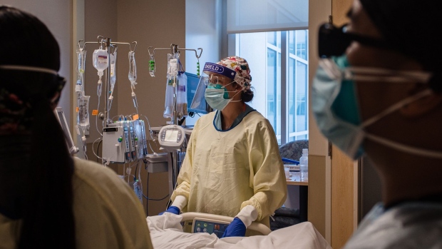 Healthcare workers assist a patient in the Covid-19 Intensive Care Unit (ICU) overflow area at Providence Holy Cross Medical Center in Mission Hills, California, U.S., on Friday, Feb. 5, 2021. California’s 14-day positive test rate dropped to 6.6%, down from 12.7% a month ago and the lowest since Nov. 30. Photographer: Ariana Drehsler/Bloomberg