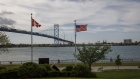 Canadian and American flags fly near the base of the Ambassador Bridge connecting Canada to the U.S. in Windsor, Ontario.