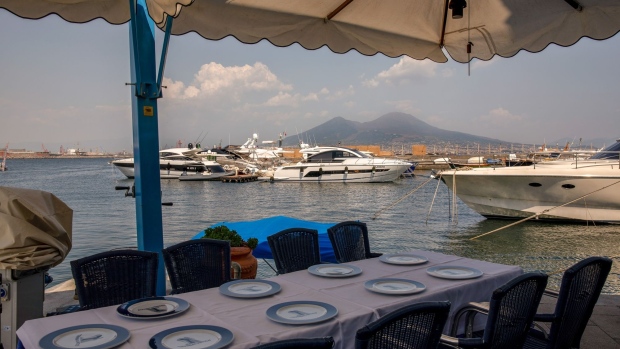 A table set at a restaurant on the harbor front in Naples, Italy, on Wednesday, July 21, 2021. Italy is the biggest recipient of the European Union pandemic aid and Prime Minister Mario Draghi is devoting almost 40% of his 260 billion-euro ($316 billion) recovery program to the regions left behind. Photographer: Alessio Paduano/Bloomberg
