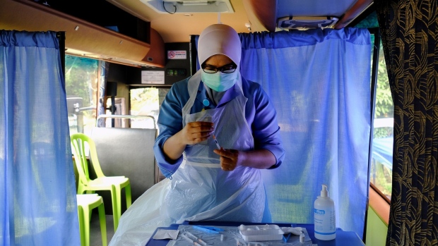 A health worker prepares a dose of the Pfizer-BioNTech Covid-19 vaccine at a mobile vaccination clinic set up at Kampung Bukit Perah in Kuala Langat, Selangor, Malaysia, on Thursday, July 15, 2021. Malaysia's accelerated vaccine roll-out has allowed the government to ease curbs in eight states even as the nationwide cases topped a record 11,000 for a second straight day on Wednesday. Selangor, the nation's most industrialized state, and the capital city of Kuala Lumpur continue to account for the bulk of the daily new infections.