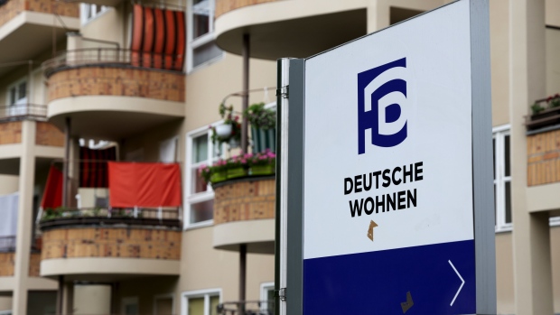 A Deutsche Wohnen SE logo near balconies at the Siemensstadt Settlement modernist residential apartment block, a UNESCO World Heritage site managed by Deutsche Wohnen, in Berlin, Germany, on Tuesday, May 25, 2021. German residential property firm Vonovia SE agreed to acquire rival Deutsche Wohnen for about 19 billion euros ($23 billion) in the biggest-ever takeover in European real estate, a deal that risks further stoking tensions over affordable housing. Photographer: Liesa Johannssen-Koppitz/Bloomberg