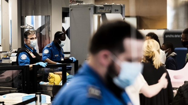 Transportation Security Administration (TSA) agents screen travelers at a checkpoint in the Detroit Metropolitan Wayne County Airport (DTX) in Romulus, Michigan, U.S., on Saturday, June 12.