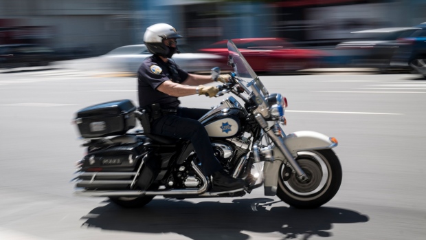 A San Francisco motorcycle officer patrols Bryant Street last year. Police in major cities are often lax in enforcing helmet and traffic laws for motorcyclists, which may foster a general sense of permissiveness.  Photographer: David Paul Morris/Bloomberg