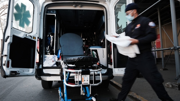 An EMT worker cleans a gurney after transporting a suspected Covid patient outside of a Brooklyn hospital on March, 29 2021 in New York City.