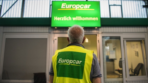 An employee beside a customer service cabin at a Europcar Mobility Group automobile rental depot in Hamburg, Germany, on Tuesday, June 29, 2021. Volkswagen AG confirmed it’s considering an acquisition of a majority stake in Europcar to expand its offerings of mobility services. Photographer: Stefanie Loos/Bloomberg