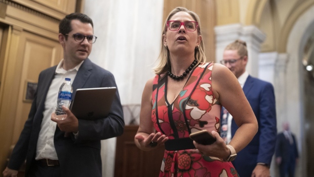 Senator Kyrsten Sinema, a Democrat from Arizona, speaks with members of the media while arriving for an infrastructure meeting in Washington, D.C., U.S., on Tuesday, July 20, 2021. The Senate majority leader cemented plans for a Wednesday cliff-hanger vote on whether to begin debate on a $579 billion infrastructure plan that does not yet exist.