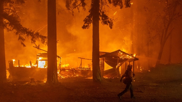 A firefighter monitors a fire as multiple structures burn in the Indian Falls neighborhood during the Dixie Fire near Crescent Mills, California on July 24.