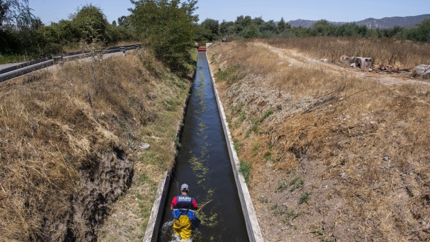 A government official measures water flow in Maule, Chile. Photographer: Tamara Merino/Bloomberg