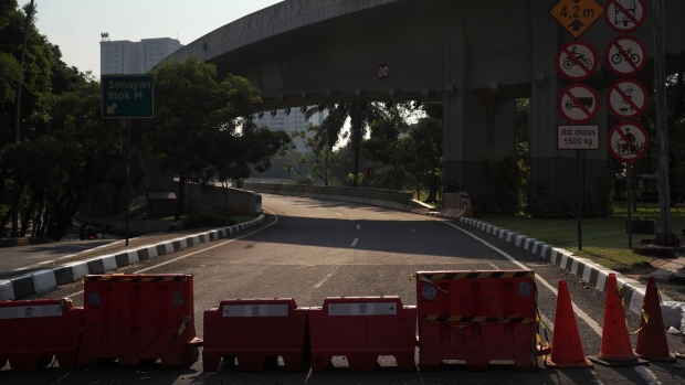 A street vendor is set up on a near-empty road in Jakarta, Indonesia, on Wednesday, July 28, 2021. Indonesia is speeding up vaccination to reach herd immunity as the highly infectious delta variant of the coronavirus continued to tear through the country.