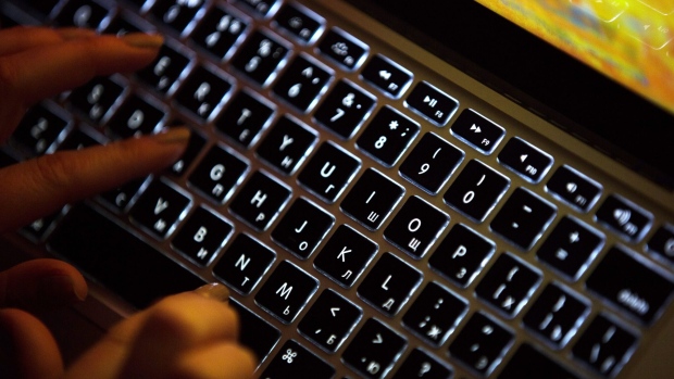 A person uses a laptop computer with illuminated English and Russian Cyrillic character keys in this arranged photograph in Moscow, Russia, on Thursday, March 14, 2019. Russian internet trolls appear to be shifting strategy in their efforts to disrupt the 2020 U.S. elections, promoting politically divisive messages through phony social media accounts instead of creating propaganda themselves, cybersecurity experts say. Photographer: Andrey Rudakov/Bloomberg