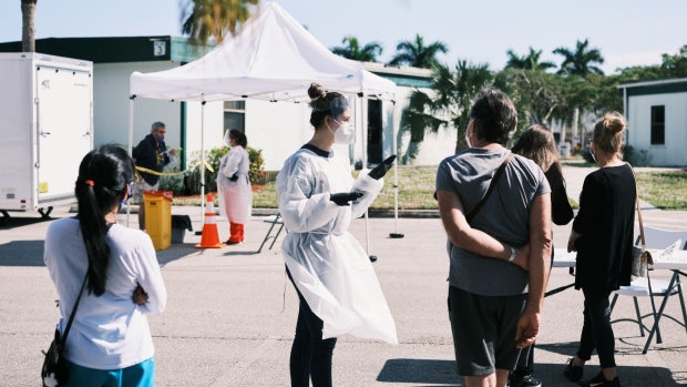 Lee County residents fill out forms prior to receiving a Covid-19 test at a testing site in Cape Coral, Florida, U.S., on Monday, Jan. 4, 2021. Florida, one of the hardest hit states in the spring surge, shattered its its previous record for new infections, at 17,192 in one day. Photographer: Zack Wittman/Bloomberg