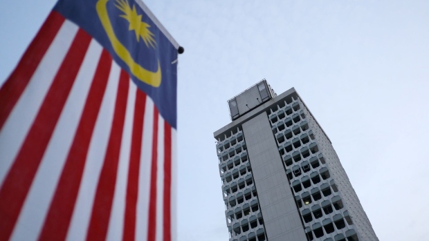 A Malaysian flag stands next to the Parliament building in Kuala Lumpur, Malaysia, on Thursday, Jan. 31, 2019. Malaysia has crowned King Sultan Abdullah Sultan Ahmad in a traditional ceremony, after the previous monarch stepped down midway through his term in an unprecedented abdication. Photographer: Samsul Said/Bloomberg
