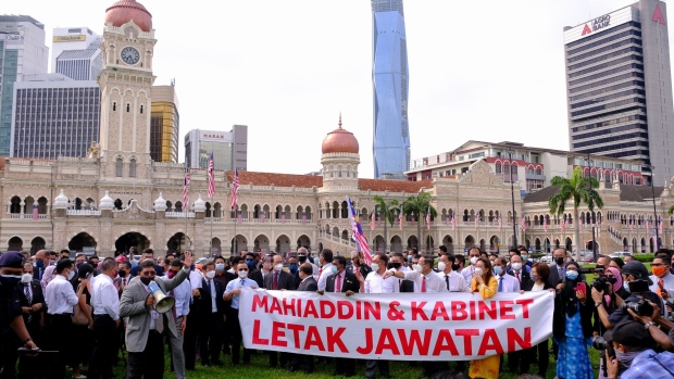 Anwar Ibrahim, Malaysia's opposition leader, center, and other opposition lawmakers hold up a banner at Merdeka Square in Kuala Lumpur, Malaysia, on Monday, Aug. 2, 2021. Malaysian opposition lawmakers marched toward the parliament building in Kuala Lumpur to demand Prime Minister Muhyiddin Yassin's resignation, after officials postponed the day's sitting indefinitely to prevent the spread of Covid-19 in the house.