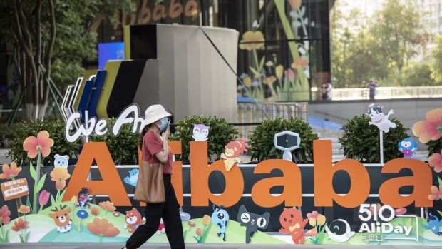 A person walks past a sign at the Alibaba Group Holding Ltd. headquarters in Hangzhou, China, on Saturday, May 8, 2021. Alibaba is scheduled to report fourth-quarter results on May 13. Photographer: Qilai Shen/Bloomberg
