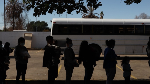 Migrants stand in line outside the Holding Institute shelter in Laredo, Texas, U.S., on Saturday, May 15, 2021. President Joe Biden sought to ease tensions with his political allies by quadrupling the limit on the number of refugees who can enter the U.S. after months of administration wavering and reversals over increasing the cap.