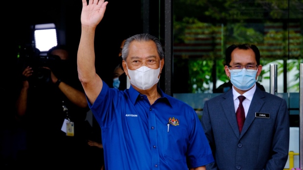 Muhyiddin Yassin, Malaysia's prime minister, waves as he arrives to receive the Pfizer-BioNTech Covid-19 vaccine at the district health office in Putra Jaya, Malaysia, on Wednesday, Feb. 24, 2021. Malaysia started its Covid-19 vaccination program, two days ahead of schedule, with Muhyiddin the first to receive the shot.