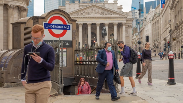Commuters emerge from Bank Underground station in the City of London, U.K., on Thursday, July 1, 2021. With the vast majority of the Square Mile’s 500,000 office staff working from home during the pandemic, once-bustling streets have been largely deserted.