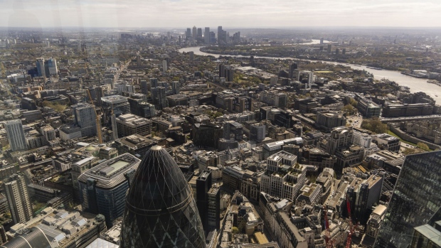 The skyscraper at 30 St Mary Axe, also known as The Gherkin, in the City of London, bottom left, and the Canary Wharf, business, financial and shopping district, top center, in London, U.K., on Monday, April 26, 2021. In a financial hub that draws more international capital than any other, the fate of the older buildings could hit the fortunes of some of the world’s biggest real-estate investors, from China Investment Corp. to Norway's sovereign wealth fund and Malaysia's biggest pension fund. Photographer: Jason Alden/Bloomberg