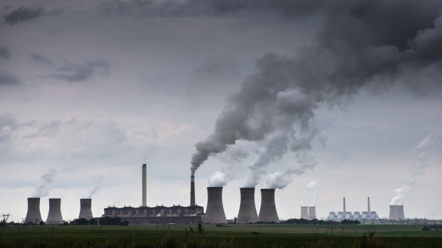 Emissions rise from the cooling towers of the Eskom Holdings SOC Ltd. Matla coal-fired power station, as the Eskom Holdings SOC Ltd. Kriel coal-fired power station stands beyond in Mpumalanga, South Africa, on Monday, Dec. 23, 2019. The level of sulfur dioxide emissions in the Kriel area in Mpumalanga province only lags the Norilsk Nickel metal complex in the Russian town of Norilsk, the environmental group Greenpeace said in a statement, citing 2018 data from NASA satellites.