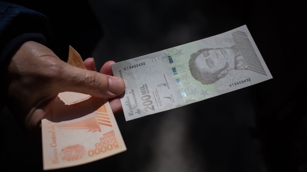 A person holds a 200,000 bolivar banknote outside a bank in Caracas, Venezuela, on Monday, March 15, 2021. Venezuela began circulating new 200,000, 500,000 and 1,000,000 bolivar notes as hyperinflation renders most bills worthless, forcing citizens to turn to the U.S. dollar for everyday transactions. Photographer: Manaure Quintero/Bloomberg
