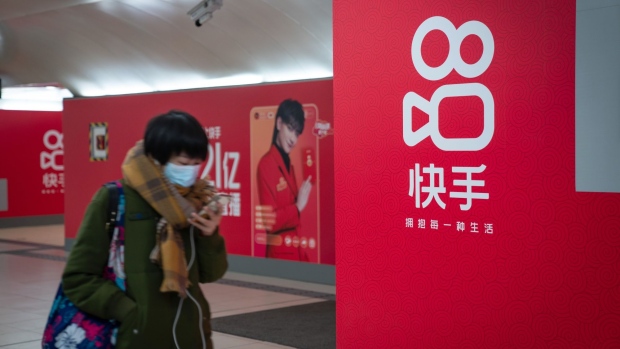 A passenger walks past Kuaishou Technology advertisements at a subway station in Beijing, China, on Wednesday, Feb. 3, 2021. Kuaishou Technology, the operator of China's most popular video service after ByteDance Ltd.'s Douyin, raised HK$42 billion ($5.4 billion) after pricing its Hong Kong initial public offering at the top of a marketed range. Photographer: Yan Cong/Bloomberg