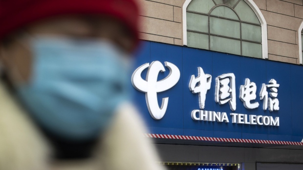 A pedestrian walks past a China Telecom Corp. store in Shanghai, China, on Wednesday, Jan. 6, 2021. The New York Stock Exchange is considering reversing course a second time to delist three major Chinese telecommunications firms after conferring further with senior authorities on how to interpret an executive order President Donald Trump issued Nov. 12, according to people familiar with the matter. Photographer: Qilai Shen/Bloomberg