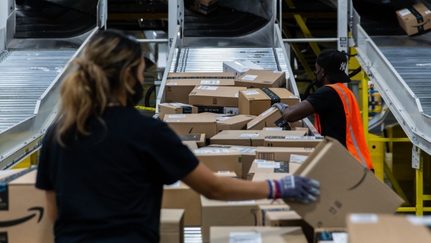 Workers retrieve boxes at an Amazon fulfillment center on Prime Day in Raleigh, North Carolina, U.S., on Monday, June 21, 2021. Amazon.com Inc.'s annual Prime Day sale, which begins Monday, arrives as the world grapples with the lingering effects of the pandemic.