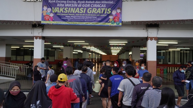 Members of the public wait in line to receive the Sinovac Biotech Covid-19 vaccine at a vaccination center set up at GOR Ciracas Stadium in Jakarta, Indonesia, on Wednesday, Aug. 4, 2021. Southeast Asia’s largest economy has been topping the world’s tally of daily Covid-19 deaths as the delta variant spreads through the country and overwhelms its hospitals.