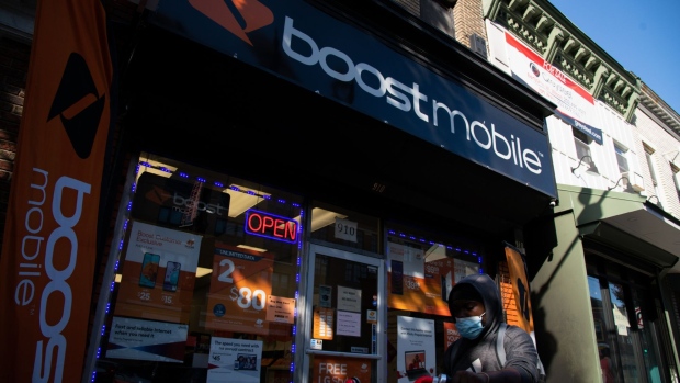 A pedestrian wearing a protective mask walks past a Boost Mobile store in Washington, D.C., U.S., on Tuesday, Oct. 6, 2020. For several months the Trump administration has operated at the White House in violation of several D.C. virus regulations including holding gatherings exceeding the 50-person limit where most attendees did not wear masks.