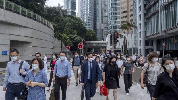 Commuters walk along a sidewalk next to the HSBC Holdings Plc headquarters building in the Central district of Hong Kong, China, on Monday, June, 7, 2021. Goldman Sachs Group Inc. and HSBC are opening their offices fully in Hong Kong as a fourth wave of infections was contained and the U.S. investment bank said half of its staff in the financial hub are now vaccinated.