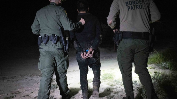A Central American migrant is apprehended by U.S. Border Patrol agents after crossing the Rio Grande in Roma, Texas, U.S., on Saturday, June 12, 2021. Legislation that would grant a path to citizenship to young immigrants brought to the U.S as children has triggered a fresh round of partisan skirmishes over border security, as the fate of a program shielding them from deportation hangs in the balance. Photographer: Nicolo Filippo Rosso/Bloomberg