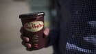 A customer holds a coffee cup outside a Tim Hortons Inc. restaurant in Toronto, Ontario, Canada, on Monday, Sept. 16, 2013. Tim Hortons Inc. Chief Executive Officer Marc Caira said Canadas largest coffee and doughnuts chain must succeed in the U.S. as competition brings slower growth at home.