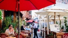 A server wearing a protective mask helps customers sitting in the outdoor dining section of a restaurant in the Little Italy neighborhood of New York.