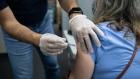 A pharmacist administers a third dose of the Pfizer-BioNTech Covid-19 vaccine to a customer at a pharmacy in Livonia, Michigan, U.S., on Tuesday, Aug. 17, 2021. Americans with weakened immune systems will be allowed to get three shots of Covid-19 vaccine after U.S. regulators authorized giving an extra dose to the most vulnerable people. Photographer: Emily Elconin/Bloomberg