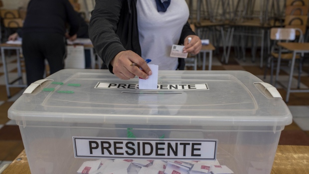 A voter casts a ballot at a polling station during primary presidential elections in Santiago, Chile, on Sunday, July 18, 2021. Chileans went to the polls Sunday in a primary election that will narrow a crowded field of candidates competing for the presidency amid a backdrop of lingering social unrest.