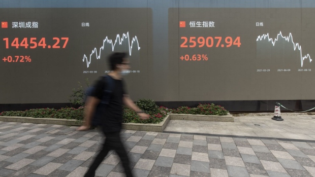 A public screen displays the Shenzhen Stock Exchange and the Hang Seng Index figures in Shanghai, China, on Wednesday, Aug. 18, 2021. President Xi Jinping said China must pursue "common prosperity," in which wealth is shared by all people, as a key feature of a modern economy, while also curbing financial risks. Photographer: Qilai Shen/Bloomberg