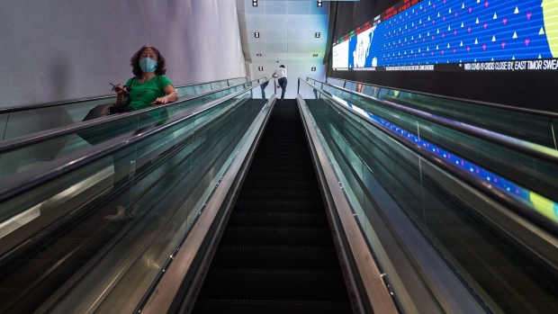 People use the escalator at the Singapore Exchange Ltd. (SGX) headquarters in Singapore, on Wednesday, Feb. 17, 2021. SGX is exploring mergers and acquisitions to drive its ambitions as a multi-asset exchange.