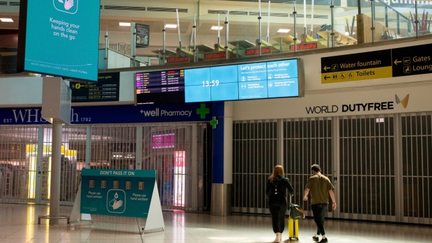 Travelers walk past closed shops in the departure lounge at London Gatwick Airport in Crawley, U.K. in June 2020.